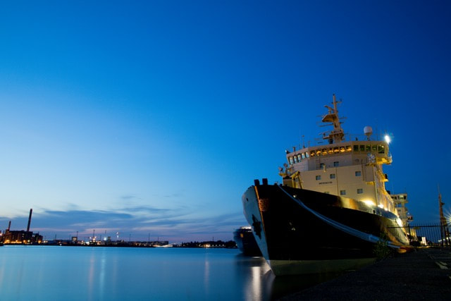 A ship anchored in a harbor at dusk